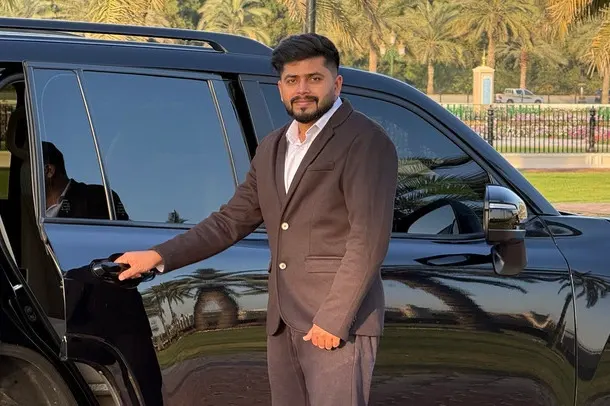 Expect the Best – CalibRide CalibRide chauffeur holding door open next to polished luxury sedan – expect the best luxury chauffeur service