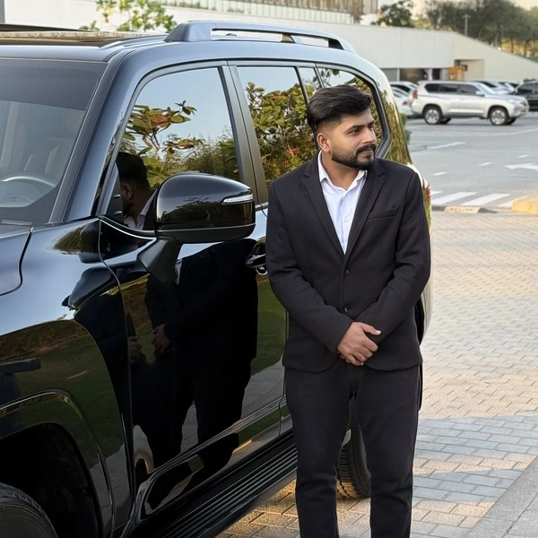 Car with driver in Abu Dhabi – chauffeur waiting beside Toyota Land Cruiser